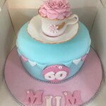 Blue cake with tea cup and flower design on top