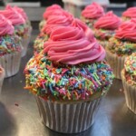 Cupcakes with rainbow sprinkles and pink frosting on top